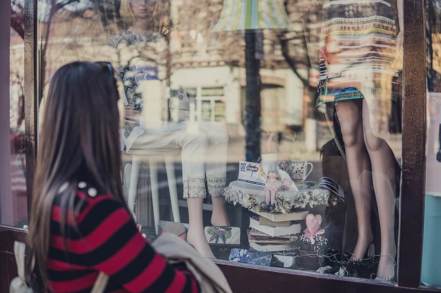 woman in red and black sweater window shopping